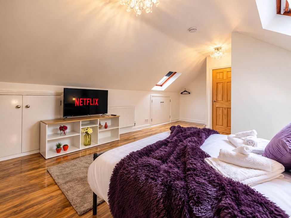 A bedroom with a bed and a television at 20A Westend Parade in Gloucester