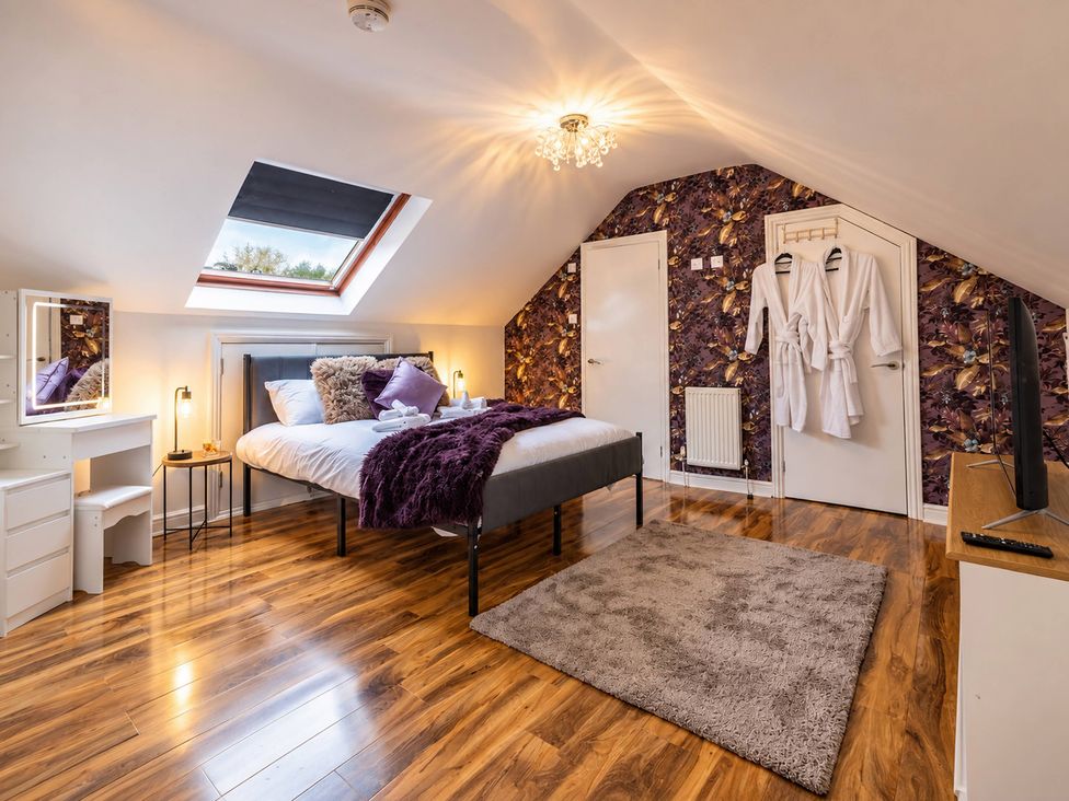 A bedroom with a bed and a television at 20A Westend Parade in Gloucester