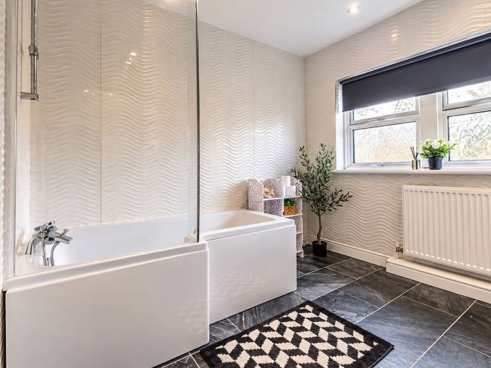 A bathroom with a bathtub and shower panel at 20A Westend Parade Gloucester