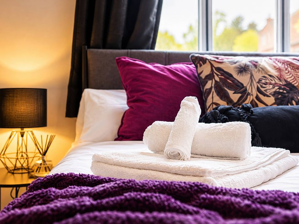 A bedroom with a bed and towels at 20A Westend Parade Gloucester