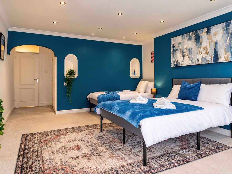 A bedroom with two beds and wall art at 20A Westend Parade in Gloucester