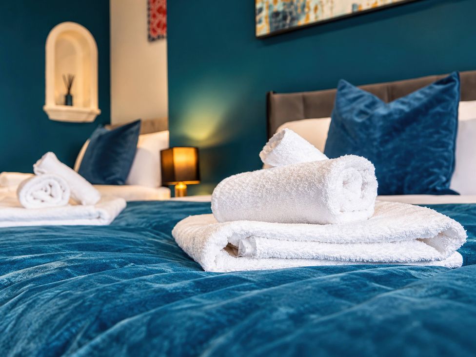 A bedroom with pillows and towels on the bed at 20A Westend Parade in Gloucester