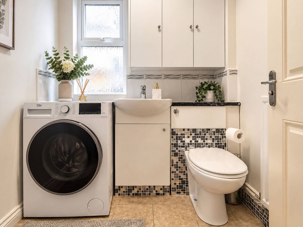 A bathroom with a washing machine and sink at 20A Westend Parade in Gloucester