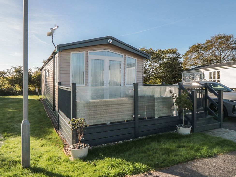 A mobile home with a deck and plants at 19 Finch in 