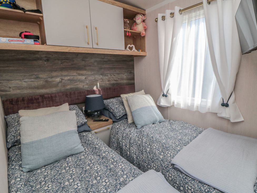 A bedroom with two beds and a shelf at 19 Finch