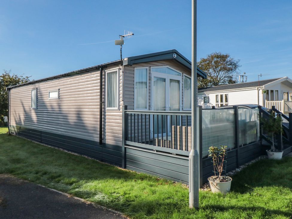 A mobile home with a deck and glass railing at 19 Finch in 