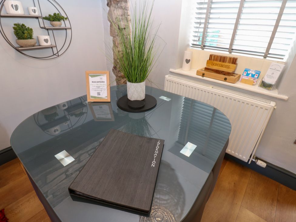 A dining room table with a menu and plant at Crown Cottage in Appleby-In-Westmorland