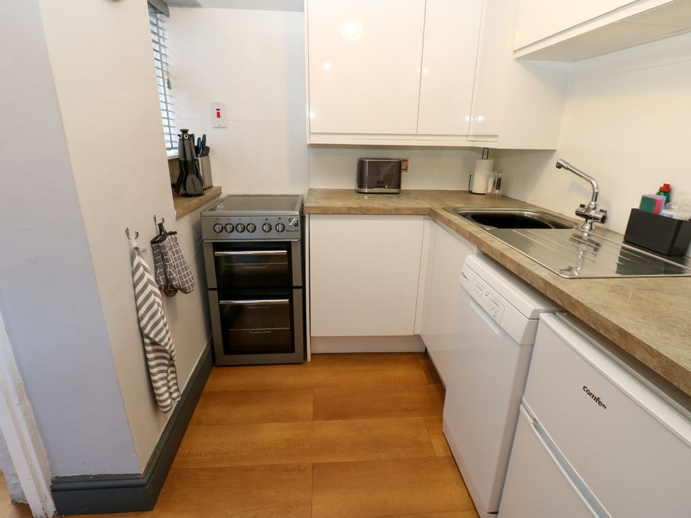 A kitchen with oven, sink, and microwave at Crown Cottage Appleby-In-Westmorland