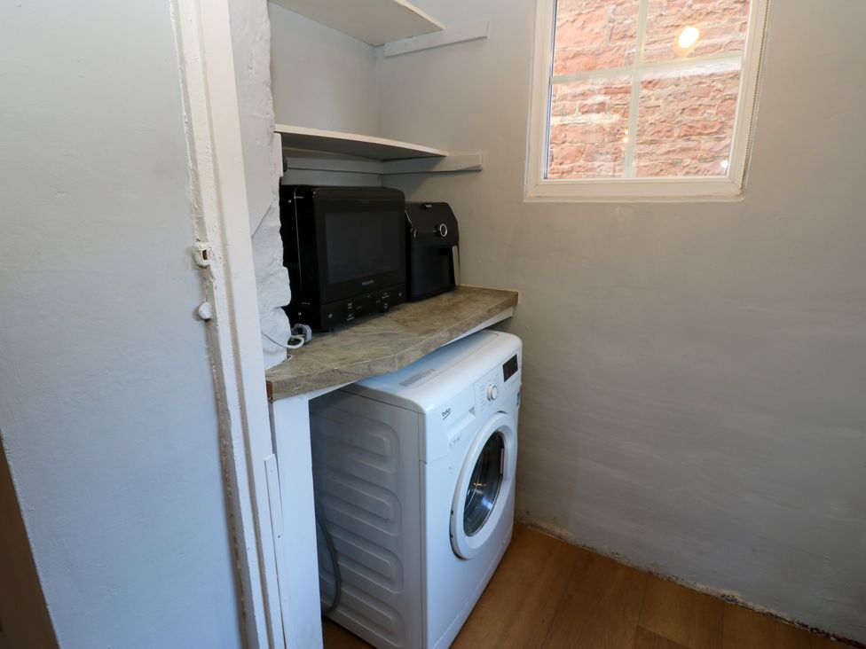A laundry room with a washing machine and appliances at Crown Cottage in Appleby-In-Westmorland
