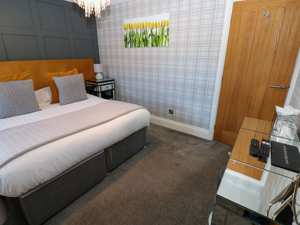 A bedroom with a bed and a glass table at Crown Cottage in Appleby-In-Westmorland