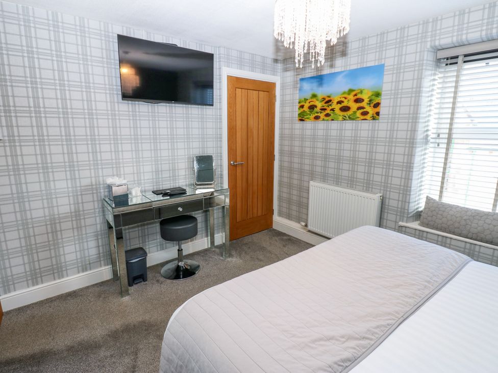 A bedroom with a bed, desk, chair, and television at Crown Cottage Appleby-In-Westmorland