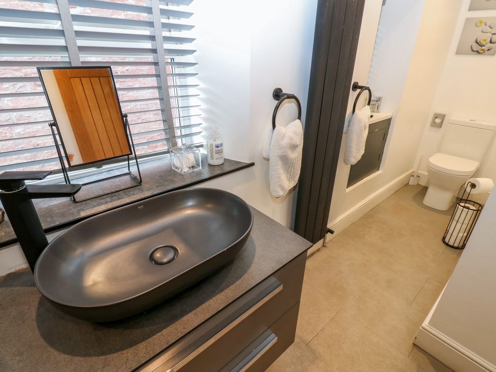 A bathroom with a sink, mirror, and toilet at Crown Cottage Appleby-In-Westmorland