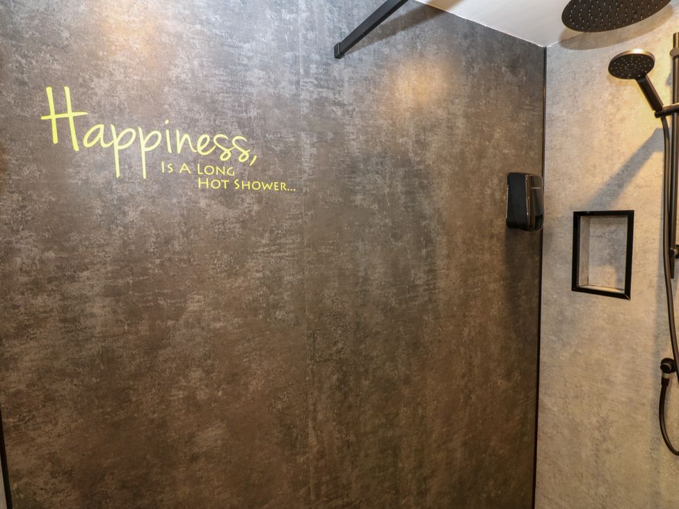 A shower with black fixtures and a quote on the wall at Crown Cottage in Appleby-In-Westmorland
