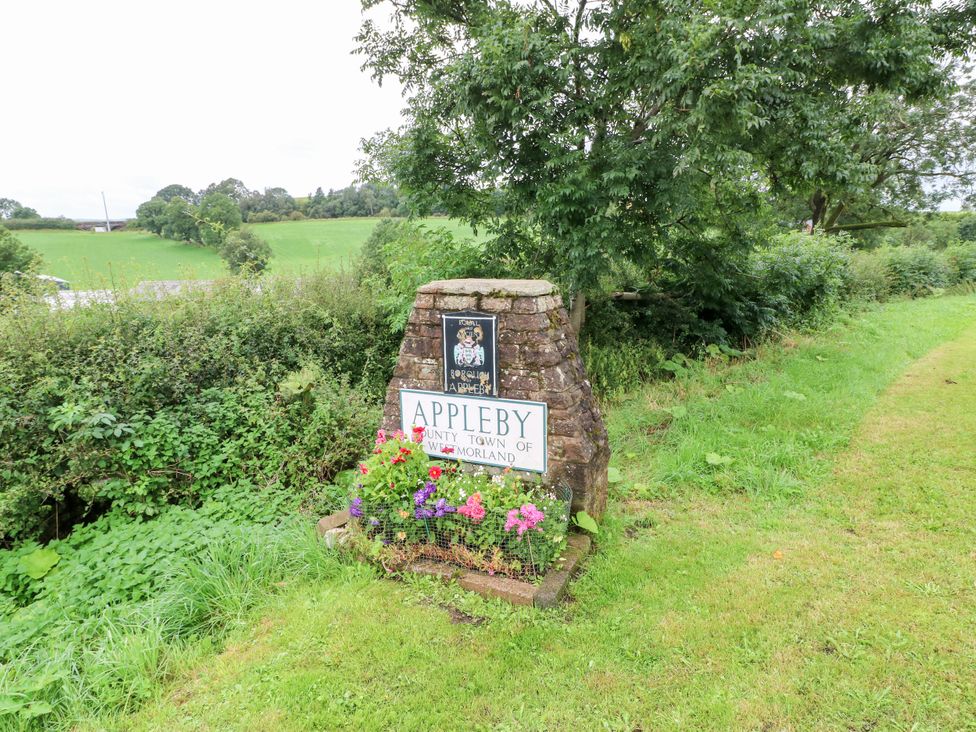 A sign with flowers at the entrance to Appleby in Appleby-In-Westmorland