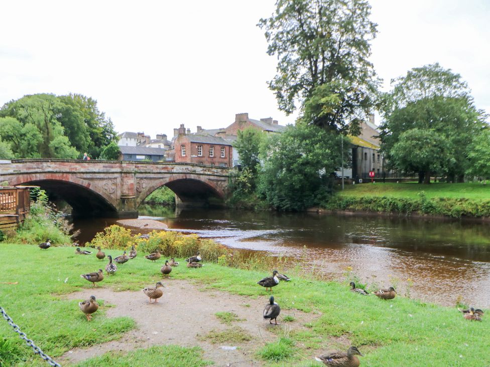 A bridge over a river with ducks in the grass at Crown Cottage Appleby-In-Westmorland