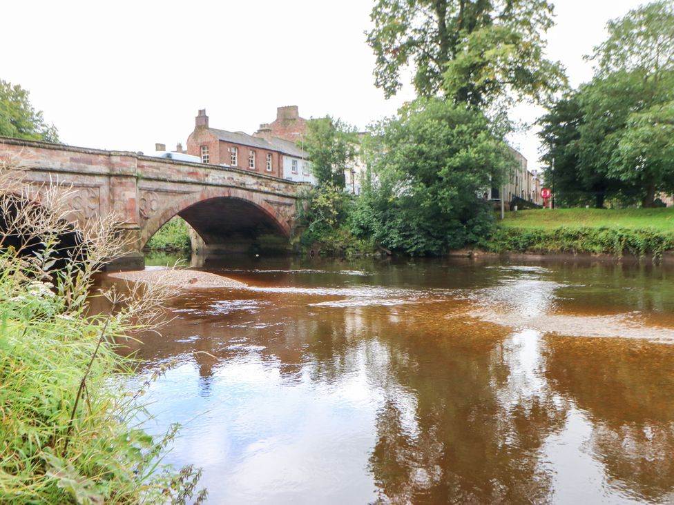 A river with a stone bridge and buildings beside it at Crown Cottage Appleby-In-Westmorland