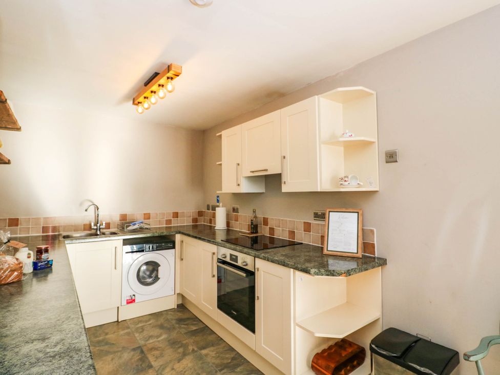 A kitchen with a washing machine and oven at Moness Garden Studio in Aberfeldy