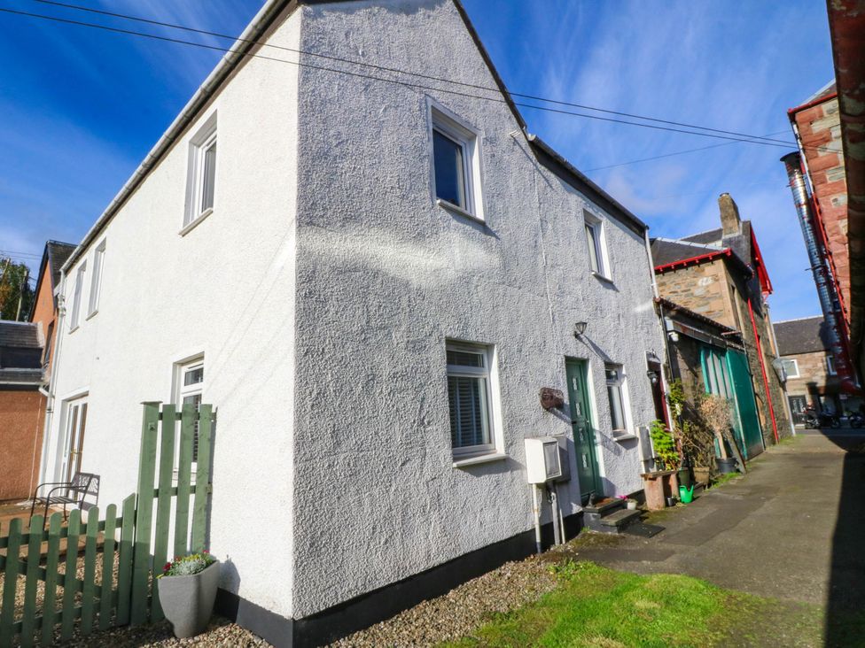 A house with a green fence and plants at Moness Garden Studio in Aberfeldy