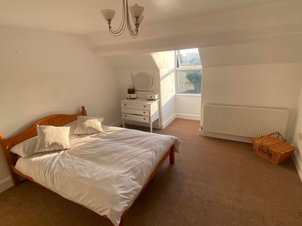 A bedroom with a bed and dresser at Strand House in Treknow near Tintagel