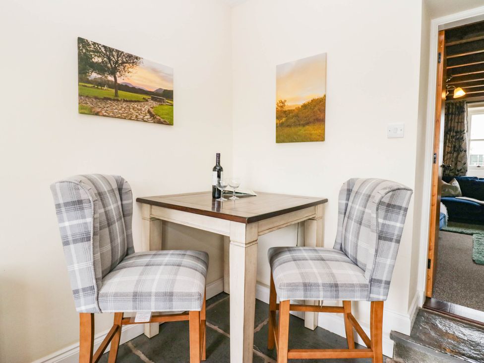 A dining area with a table and two chairs at Acorn in Cleator