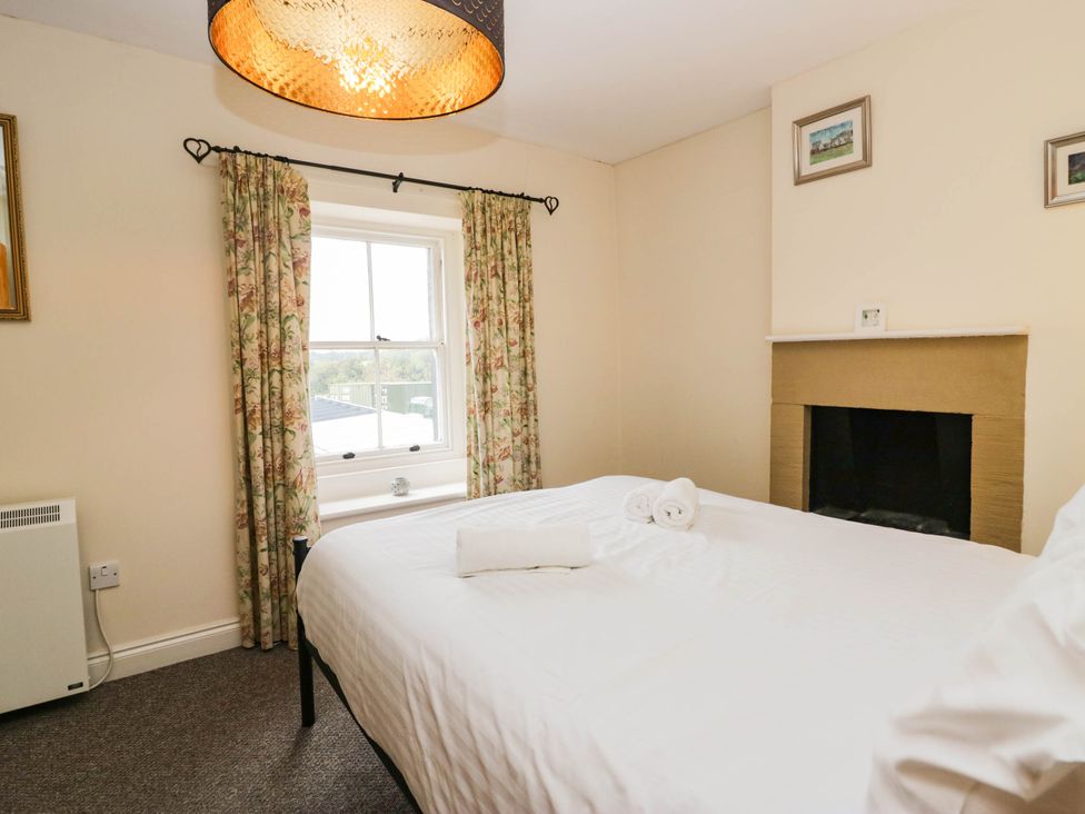 A bedroom with a bed and curtains at Acorn in Cleator