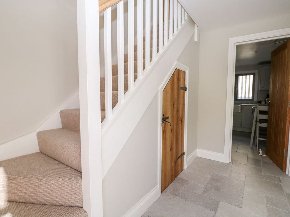 A hallway with staircase and door at The Granary 2 Bed Bordon