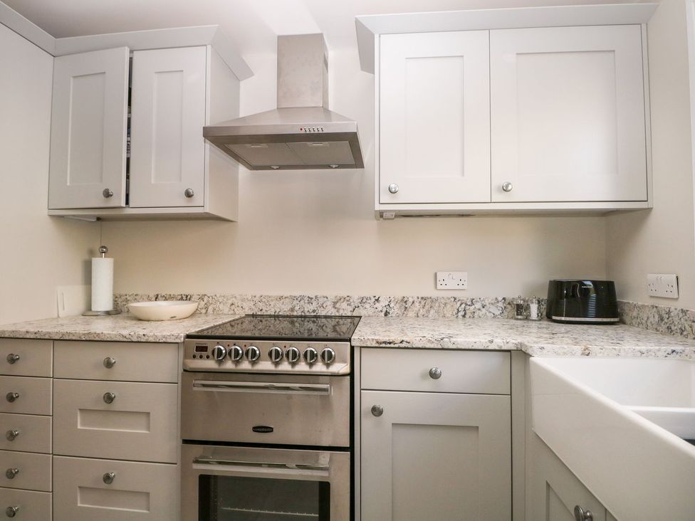 A kitchen with cabinets and a stove at The Granary 2 Bed in Bordon