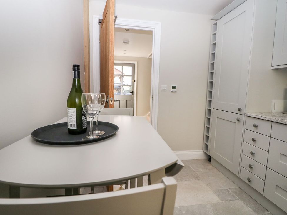 A kitchen with a table set with a wine bottle and glasses at The Granary 2 Bed in Bordon