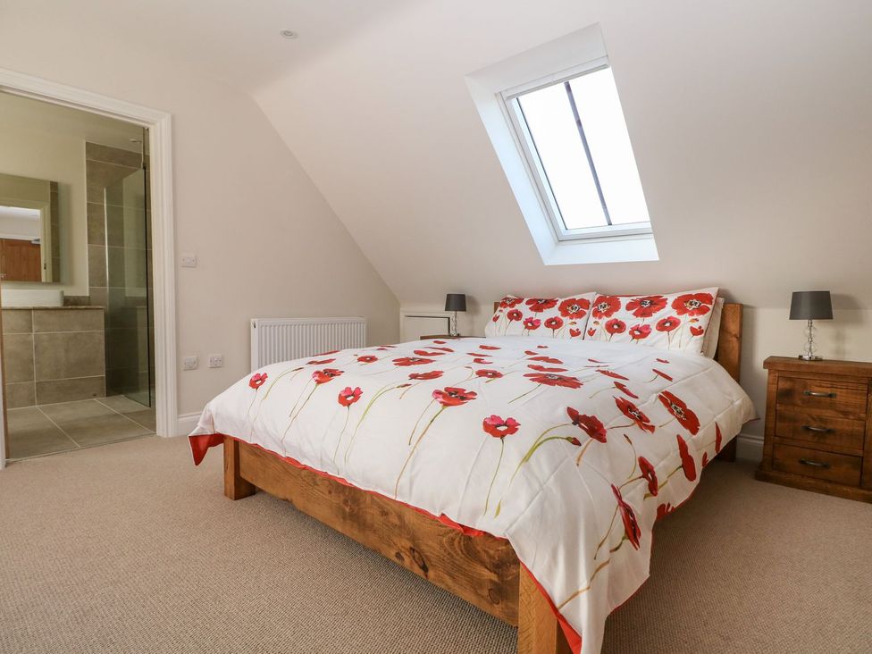 A bedroom with a bed and nightstand at The Granary 2 Bed in Bordon