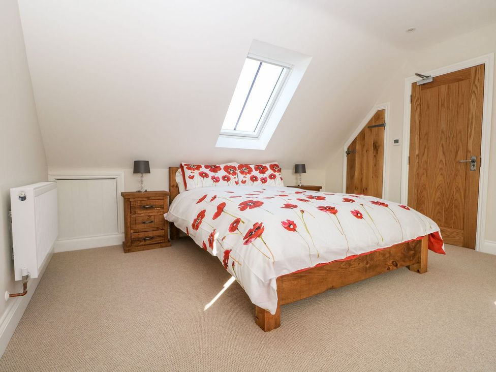 A bedroom with a bed and bedside table at The Granary 2 Bed in Bordon