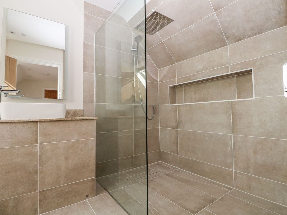 A bathroom featuring a glass shower enclosure and a sink at The Granary 2 Bed in Bordon
