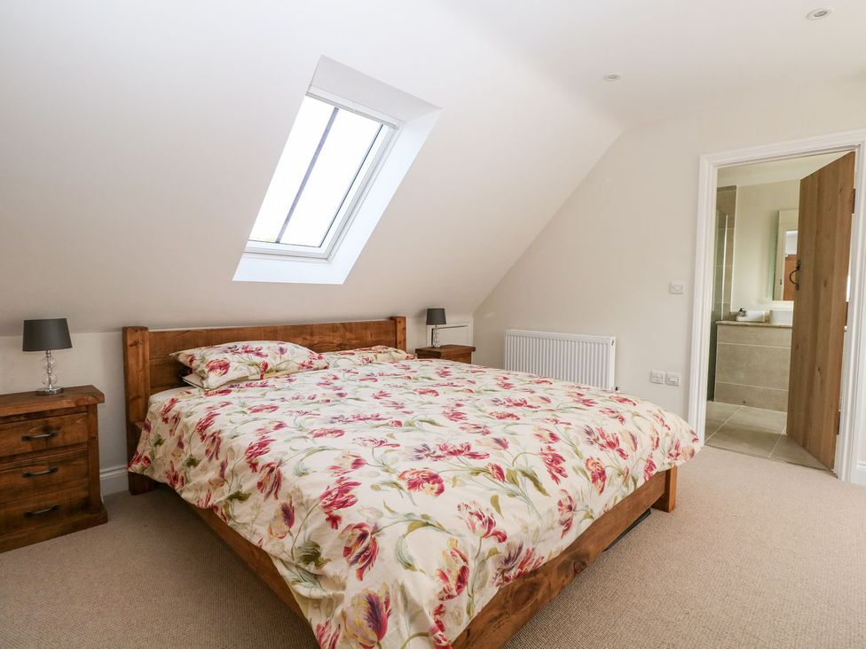 A bedroom with a bed and en-suite bathroom at The Granary 2 Bed Bordon