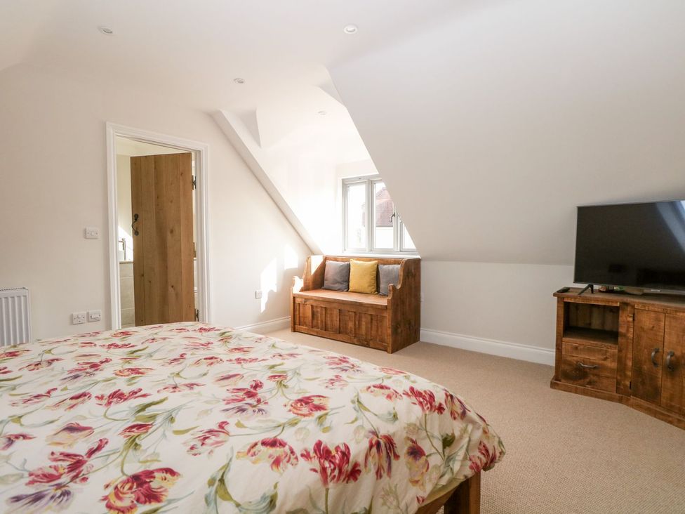 A bedroom with a bed and sofa at The Granary 2 Bed in Bordon