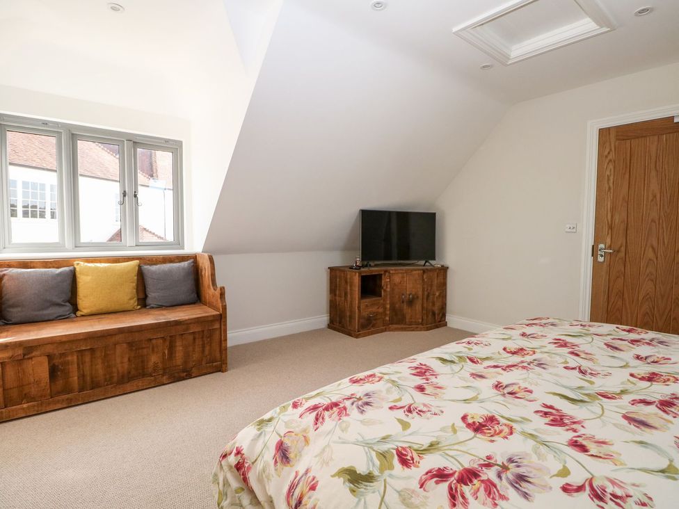A bedroom with a sofa and television unit at The Granary 2 Bed in Bordon