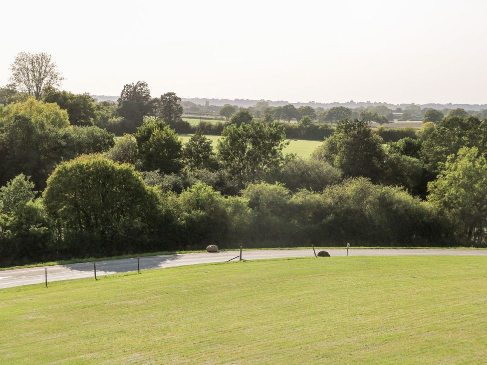 A view of a landscape with trees and a road at The Granary 2 Bed in Bordon