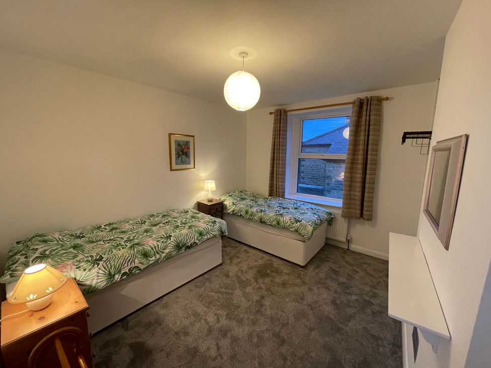 A bedroom with two beds and a window at 9 Market View Buxton