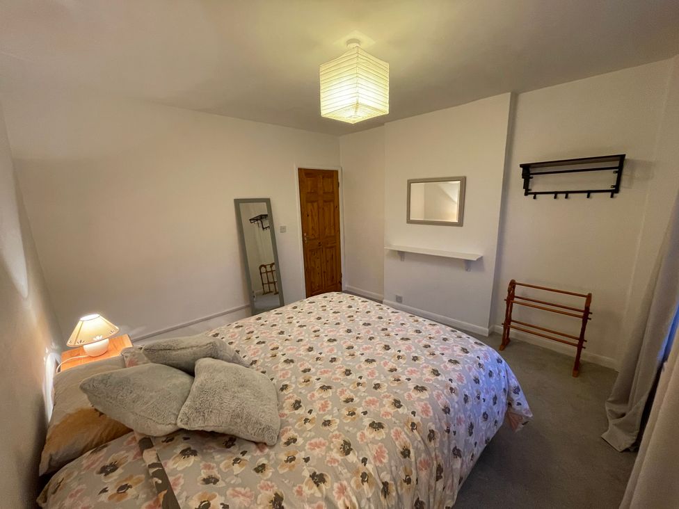 A bedroom with a bed and a mirror at 9 Market View Buxton