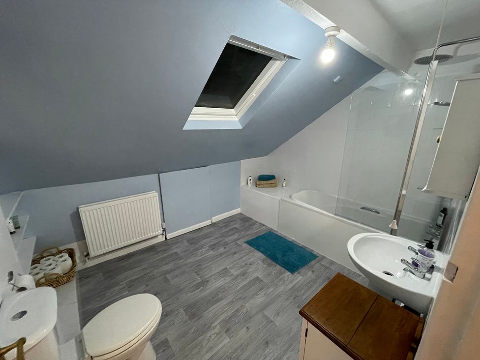 A bathroom with a bathtub, toilet, and sink at 9 Market View Buxton