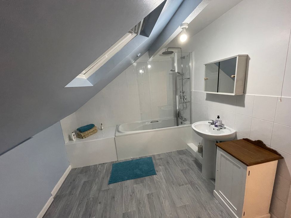 A bathroom with a bathtub, sink, and shower at 9 Market View, Buxton