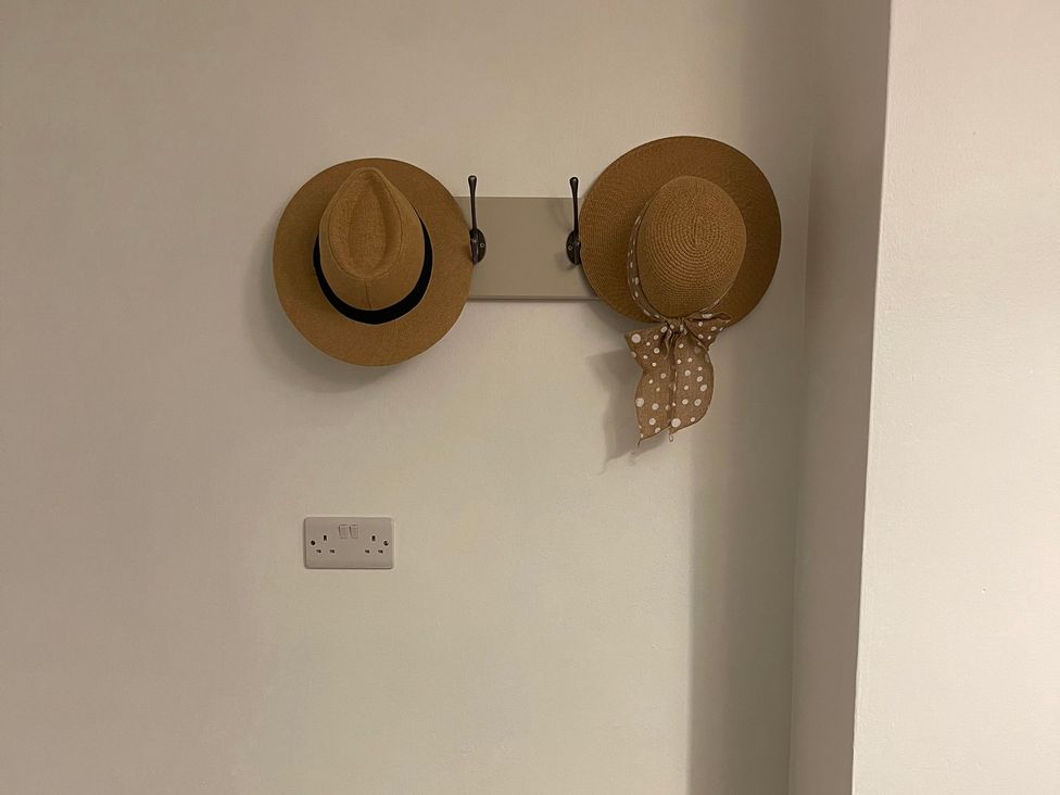 Two hats displayed on a wall rack at 9 Market View Buxton