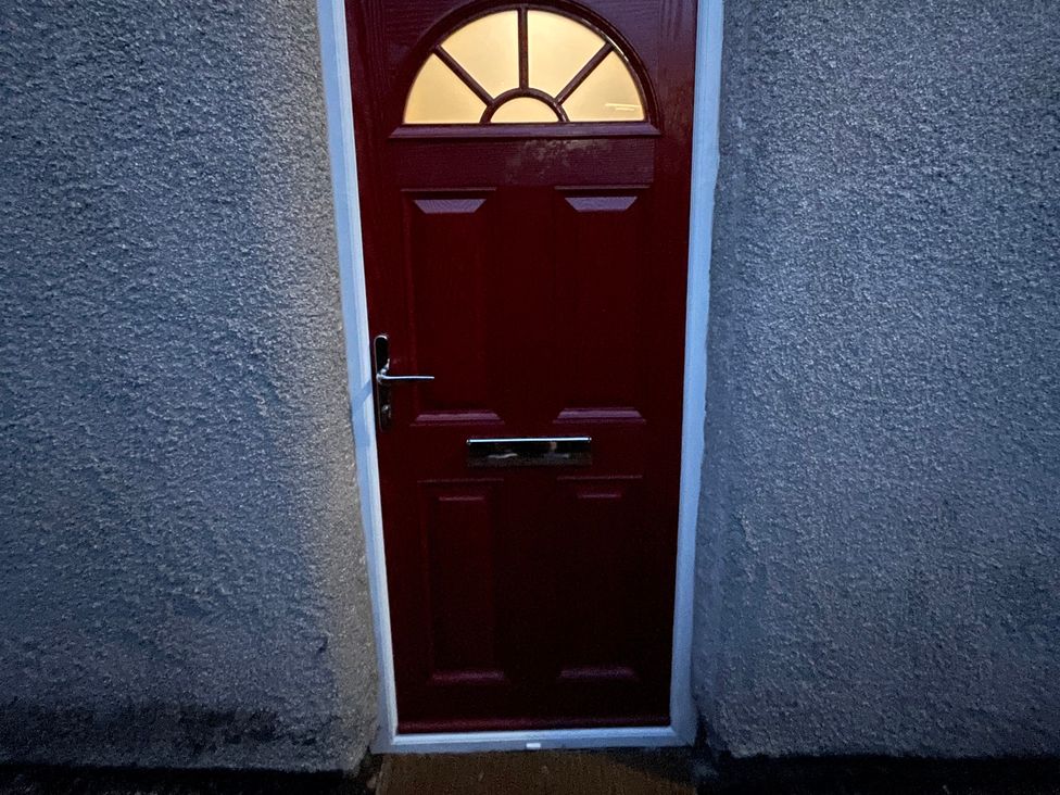 A red door with a window and letterbox at 9 Market View Buxton
