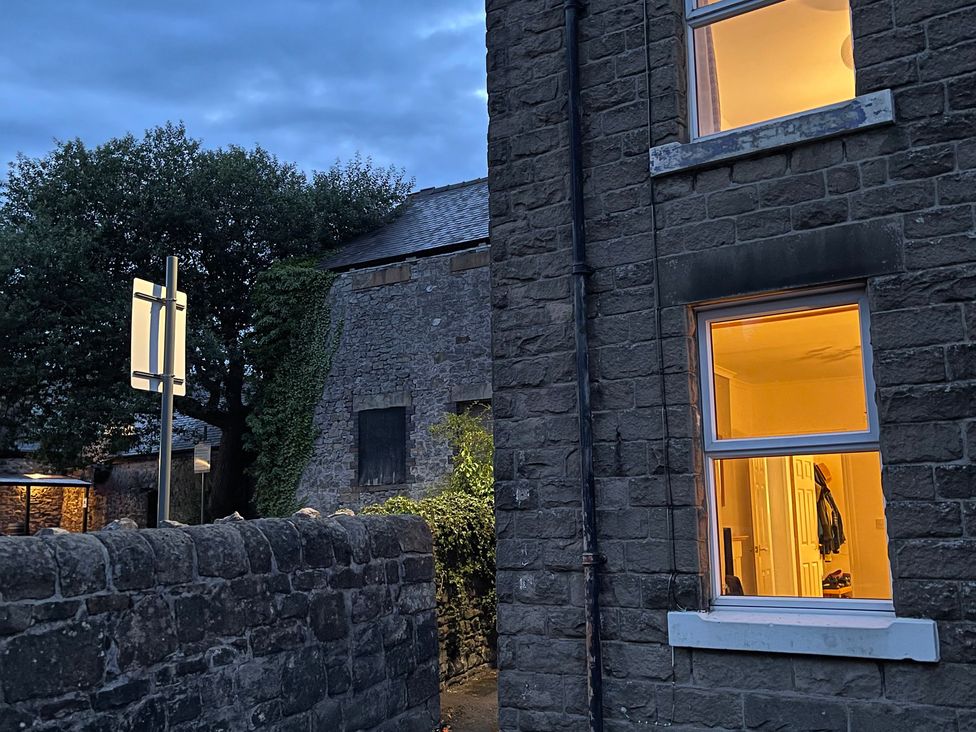 An outdoor scene with a stone wall and a window at 9 Market View in Buxton