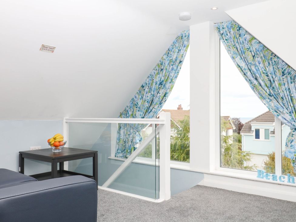 A loft area with a table and fruit bowl at Merlins Hideaway in Dawlish