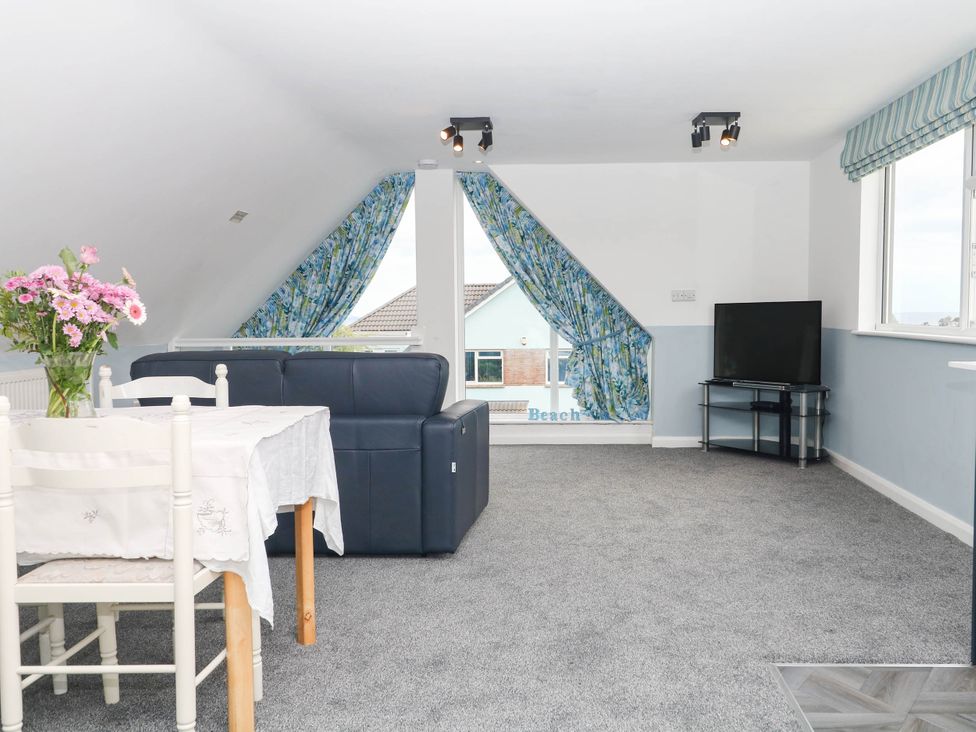 A living room with a sofa and table at Merlins Hideaway in Dawlish