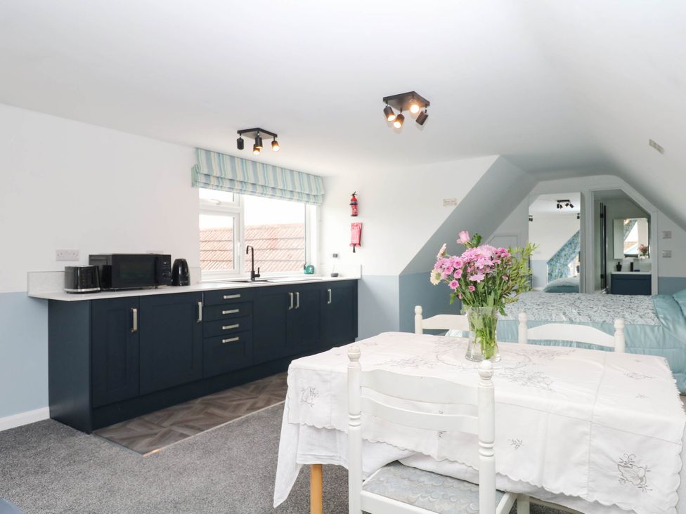 A kitchen with a dining table and chairs at Merlins Hideaway in Dawlish
