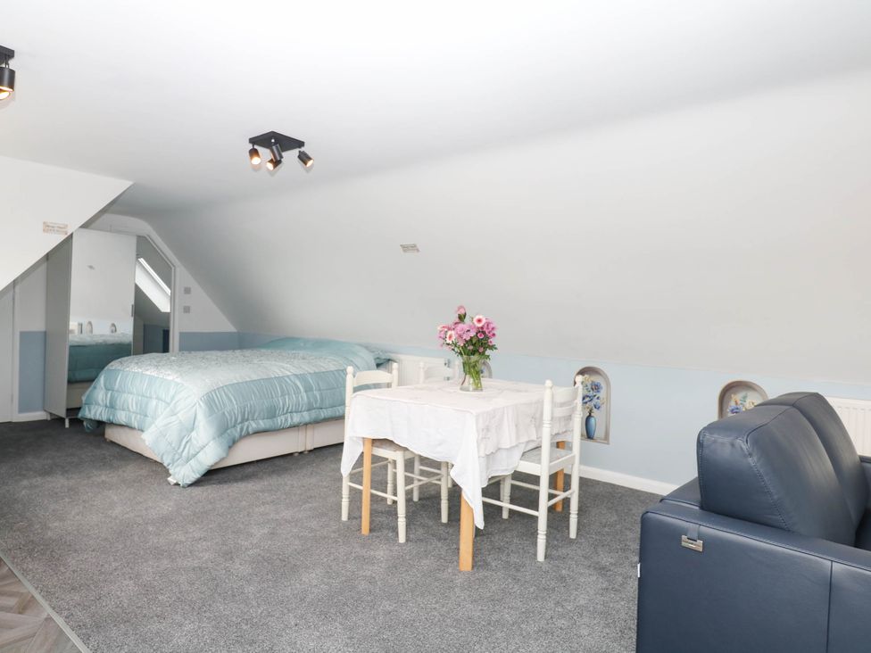 A bedroom with a bed and dining table at Merlins Hideaway in Dawlish
