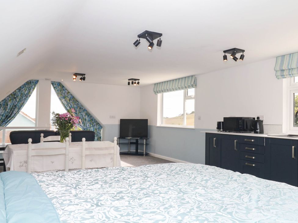 A studio with a bed and kitchenette at Merlins Hideaway in Dawlish