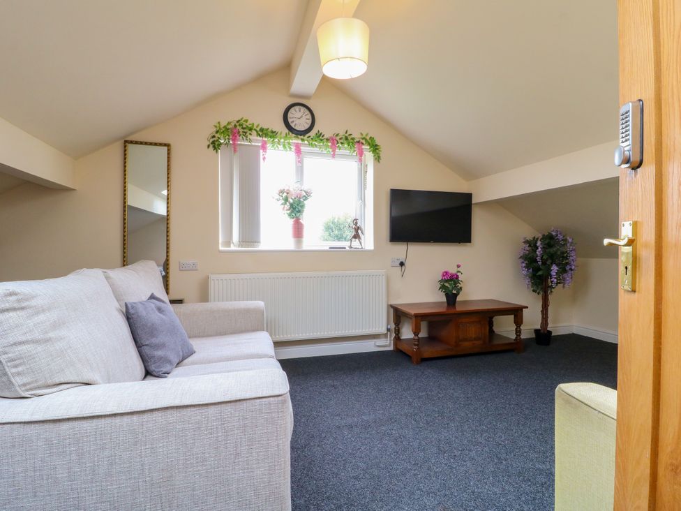 A living room with a sofa and television at Greystones - Apartment B near Buxton