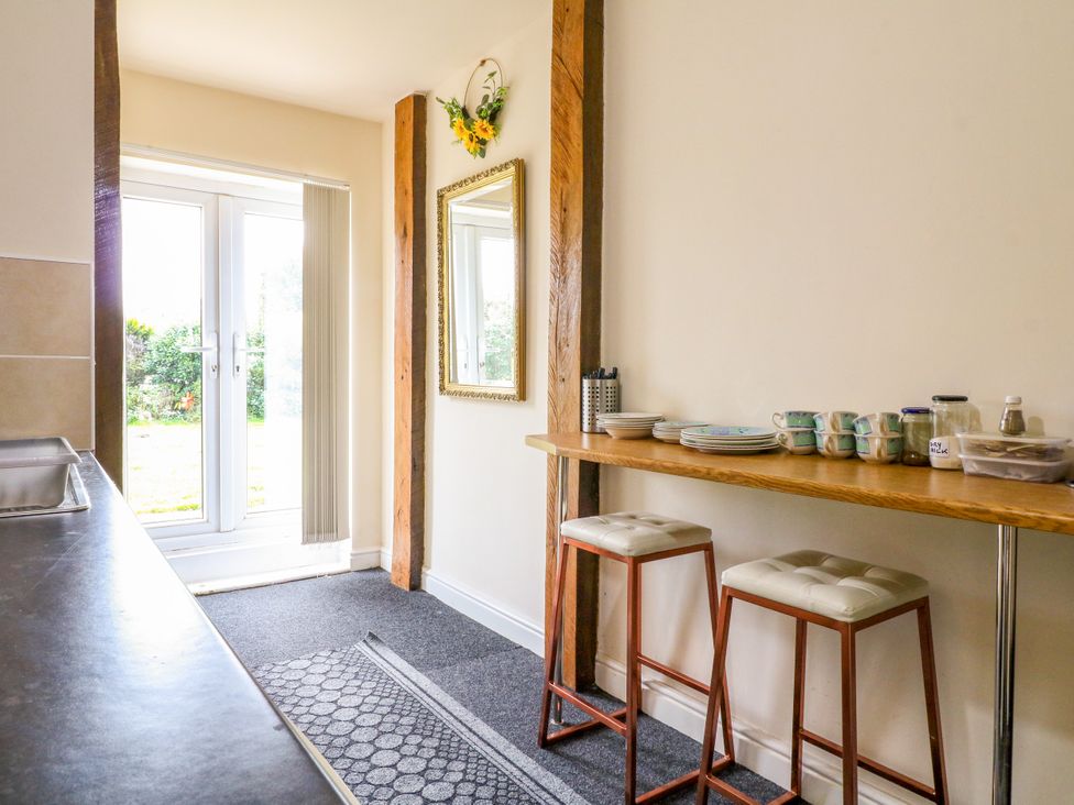 A kitchen with bar stools and a counter at Greystones - Apartment B near Buxton