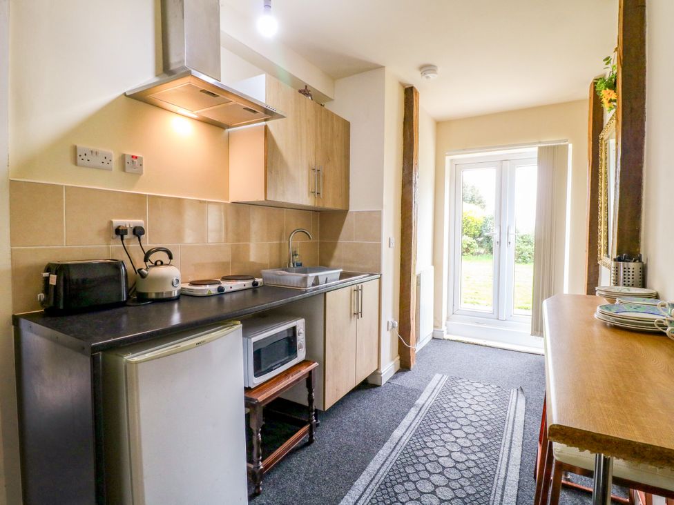 A kitchen with appliances and a table at Greystones - Apartment B near Buxton